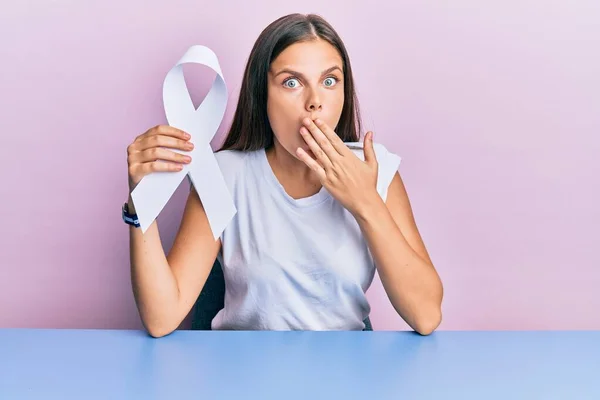 Young Caucasian Woman Holding White Ribbon Covering Mouth Hand Shocked — Stock Photo, Image