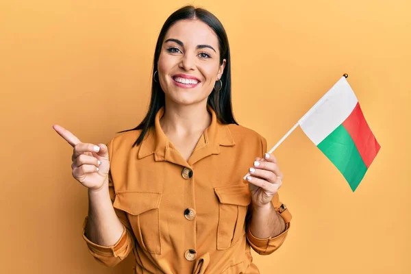 Jong Brunette Vrouw Holding Madagascar Vlag Glimlachen Gelukkig Wijzend Met — Stockfoto