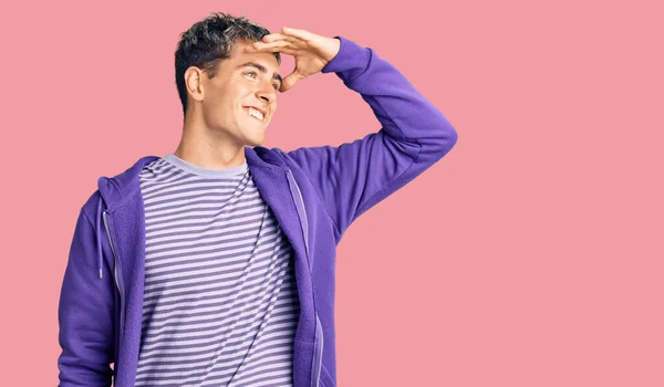 Молодой Красивый Мужчина Обычной Пурпурной Толстовке Счастлив Улыбается Глядя Вдаль — стоковое фото