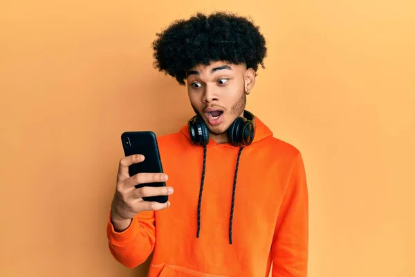 Joven Afroamericano Con Cabello Afro Usando Smartphone Asustado Sorprendido Con —  Fotos de Stock