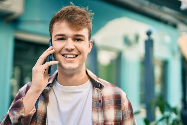 若い白人男性は 市内のスマートフォンで幸せな話を笑っています — ストック写真