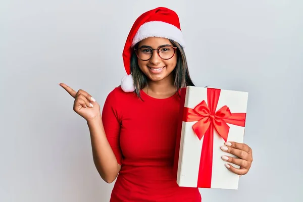 Молода Латинська Дівчина Носить Різдвяний Капелюх Тримає Подарунок Усміхнений Щасливий — стокове фото