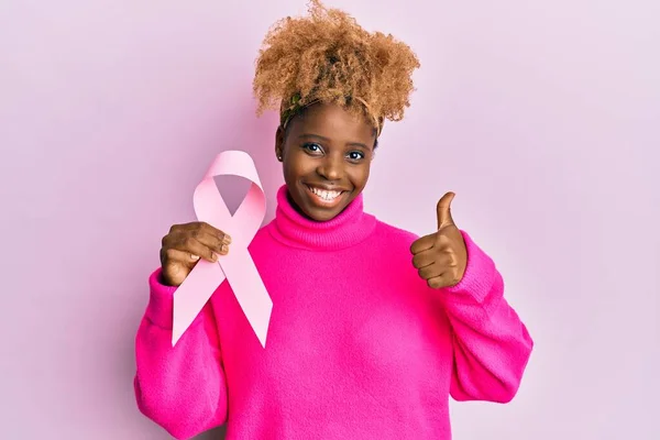 Młoda Afrykańska Kobieta Afro Włosy Trzymając Różową Wstążkę Raka Uśmiechnięta — Zdjęcie stockowe