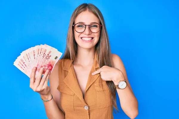 Joven Chica Rubia Sosteniendo Shekels Israelíes Señalando Con Dedo Uno —  Fotos de Stock