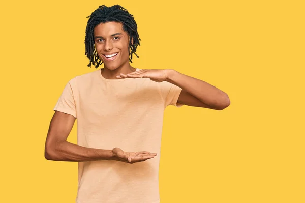 大小のサインを示す手でジェスチャーカジュアル服を着て若いアフリカ系アメリカ人男性は シンボルを測定します カメラを見て笑ってる 概念を測定し — ストック写真