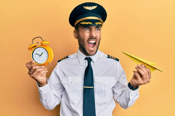 Schöner Hispanischer Pilot Mit Papierflugzeug Und Wecker Wütend Und Verrückt — Stockfoto