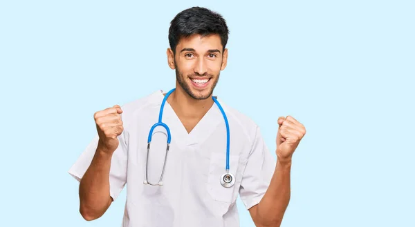 Jovem Homem Bonito Vestindo Uniforme Médico Estetoscópio Gritando Orgulhoso Celebrando — Fotografia de Stock