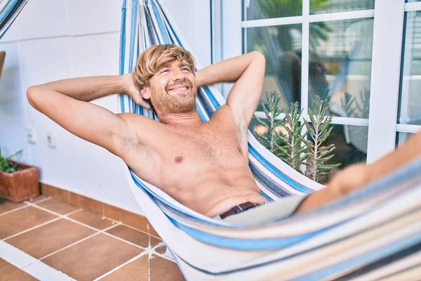 Evinin terasında orta yaşlı yakışıklı bir adam hamakta üstsüz yatıyordu.