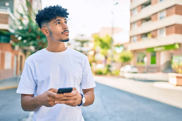 街を歩くスマートフォンを使った真剣な表情の若いアラブ人男性 — ストック写真