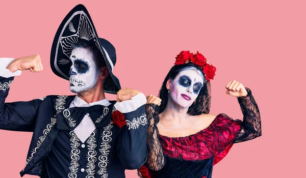 腕の筋肉を誇りに笑顔を示す背景に死んだ衣装のメキシコの日を身に着けている若いカップル フィットネスのコンセプト — ストック写真