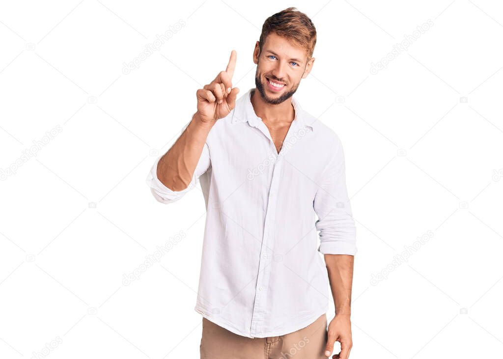 Young caucasian man wearing casual clothes showing and pointing up with finger number one while smiling confident and happy. 
