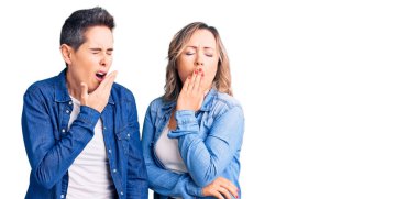 Gündelik giysiler giyen iki kadın ağızlarını elleriyle kapatmaktan sıkılmış. Huzursuz ve uykulu.. 