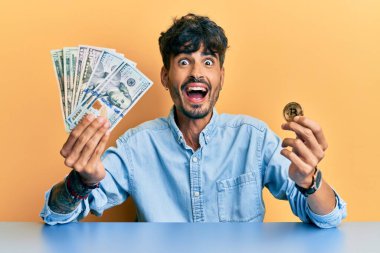 Dolarları tutan genç İspanyol adam ve Bitcoin çılgınlığı kutluyor ve başarıya hayret ediyor gözleri açık heyecanla haykırıyor. 