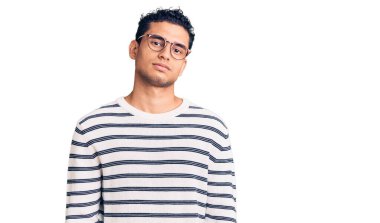 Sıradan kıyafetler ve gözlük takan İspanyol yakışıklı genç adam yüzünde ciddi bir ifadeyle rahatladı. Basit ve doğal bir şekilde kameraya bakıyorsun.. 