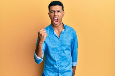 Genç Arap adam, öfkeyle bağırırken öfkeli ve öfkeli bir şekilde yumruk kaldırıyor. öfke ve agresif konsept. 