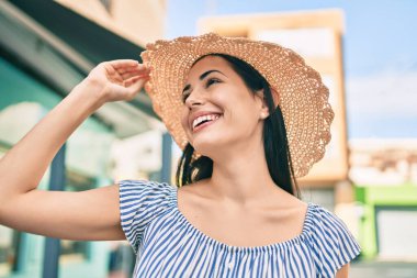 Tatildeki genç Latin turist kız şehirde mutlu gülümsüyor..