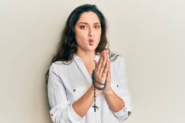 Güzel İspanyol kadın Katolik tespihiyle oynuyor. Ağızla balık suratı yapıyor ve şaşı bakıyor. Deli ve komik.. 