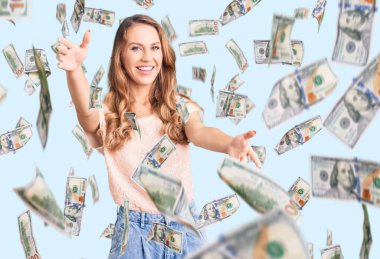 Sarı saçlı, sıradan kıyafetler giyen, kolları açık kameraya bakıp sarılmak için gülümseyen beyaz bir kadın. Mutluluğu kucaklayan neşeli bir ifade..