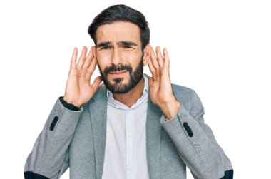 İş kıyafetleri giymiş genç İspanyol bir adam iki elini de kulak hareketlerini duymaya çalışıyor. Dedikoduya meraklı. İşitme sorunu, sağır 