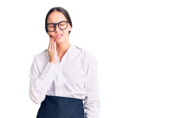 Güzel, esmer, profesyonel garson önlüğü giyen, diş ağrısı ya da diş hastalığından dolayı acı dolu bir ifadeyle dudaklarına dokunan genç bir kadın. dişçi 