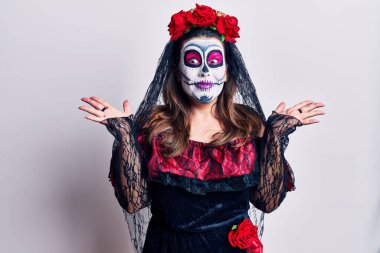 Ölü kostümü giymiş genç bir kadın çılgınlığı kutluyor ve başarıya hayret ediyor. Kolları açık, gözleri açık heyecanla haykırıyor. Kazanan konsept 