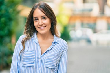 Genç İspanyol kadın gülümseyerek şehirde mutlu mesut dikiliyor..