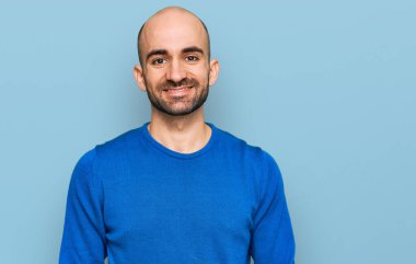 Yüzünde mutlu ve havalı bir gülümseme olan sıradan kıyafetler giyen genç İspanyol bir adam. şanslı kişi. 