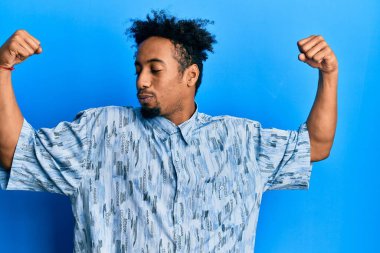 Sakallı, sıradan kıyafetler giyen, gururla gülümseyen genç Afrikalı Amerikalı adam. fitness konsepti. 