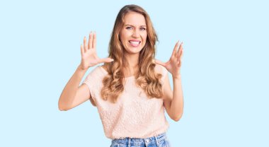 Sarı saçlı, sıradan kıyafetler giyen, korku ifadesinden korkan, genç, beyaz bir kadın. El hareketini bırak, şok içinde bağır. panik konsepti. 