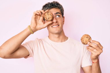 Kurabiye tutan genç yakışıklı adam yan tarafa bakıp düşünüyor.. 