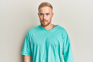 Gündelik kıyafetler giyen, kuşkucu ve gergin genç beyaz bir adam sorun yüzünden surat asıyor. negatif kişi. 