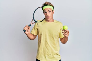 Tenis oynayan yakışıklı beyaz bir adam elinde raket ve top tutuyordu. Şaşırtmak için ağzı açık kalmış, imansız bir yüz. 