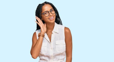 Gündelik kıyafetler ve gözlük takan, ağzı kulaklarında gülümseyen, dedikoduları ve dedikoduları dinleyen güzel İspanyol bir kadın. Sağırlık kavramı. 