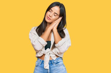 Genç, güzel İspanyol elbiseli, rahat uyuyan, yorgun ve ellerinle poz veren, gözleri kapalı bir kız.. 