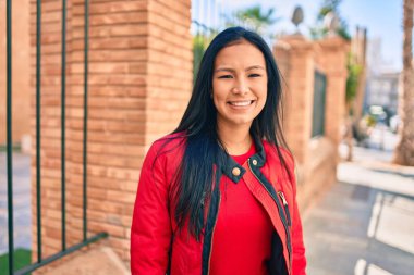 Genç Latin kadın gülümseyerek şehirde mutlu mesut yürüyor..