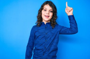 Uzun saçlı, sıradan kıyafetler giyen sevimli İspanyol çocuk başarılı bir fikri işaret ediyor. Heyecanlı ve mutlu. Bir numara.. 