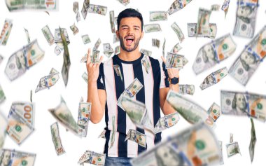 Çizgili tişört giyen, çılgın bir ifadeyle bağıran genç, yakışıklı İspanyol adam elleri havada rock sembolü yapıyor. Müzik yıldızı. ağır kavram.