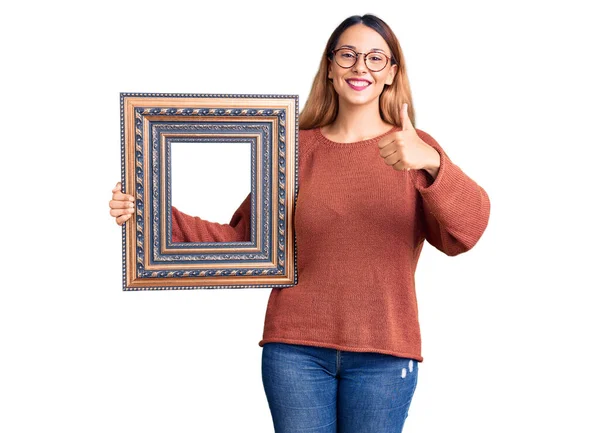 Beautiful Young Woman Holding Empty Frame Smiling Happy Positive Thumb — Stock Photo, Image