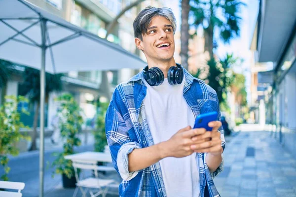 Joven Hombre Hispano Sonriendo Feliz Usando Teléfonos Inteligentes Auriculares Ciudad —  Fotos de Stock