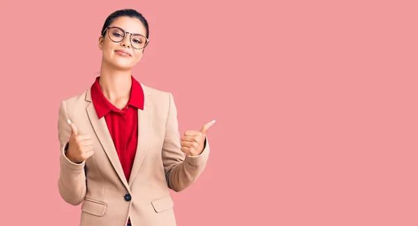 年轻漂亮的女人穿着商务衬衫 戴着眼镜 成功地做了一个积极的手势 竖起大拇指 笑容满面 喜形于色 快乐的表达和胜利的姿态 — 图库照片