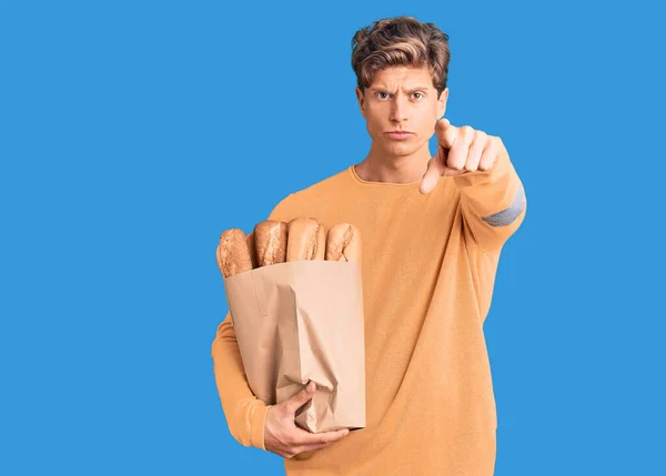 Νεαρός Όμορφος Άντρας Κρατάει Χάρτινη Σακούλα Ψωμί Που Δείχνει Δάχτυλο — Φωτογραφία Αρχείου