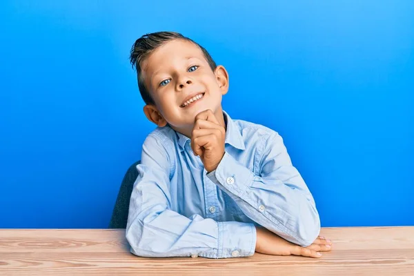 Garoto Caucasiano Adorável Vestindo Roupas Casuais Sentado Mesa Sorrindo Olhando — Fotografia de Stock