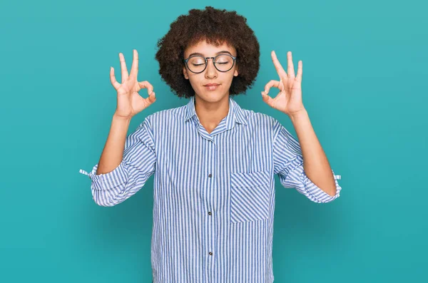 年轻的惊慌失措的女孩穿着商务衬衫和眼镜 闭着眼睛 用手指做冥想动作 瑜伽概念 — 图库照片
