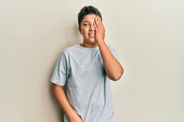 Adolescente Hispano Vistiendo Camiseta Gris Casual Cubriendo Ojo Con Mano —  Fotos de Stock
