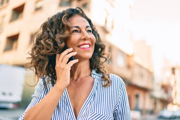 Middelbare Leeftijd Spaanse Vrouw Glimlachend Gelukkig Praten Smartphone Stad — Stockfoto