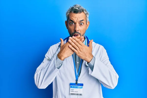 Medelålders Gråhårig Man Klädd Läkaruniform Och Stetoskop Chockade Täcka Munnen — Stockfoto