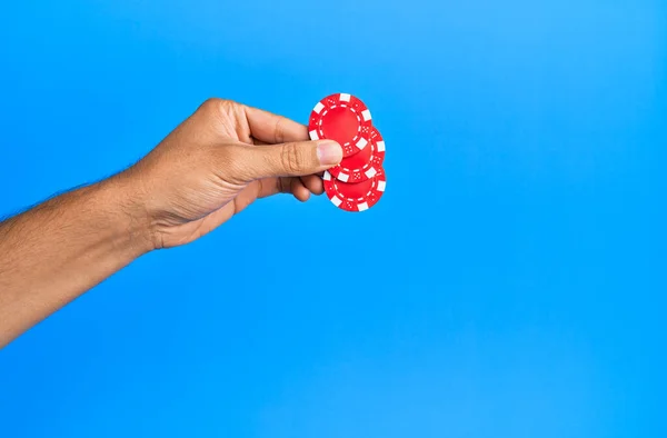 Hand Van Spaanse Man Met Casino Chips Geïsoleerde Blauwe Achtergrond — Stockfoto