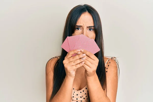Молодая Красивая Латиноамериканка Закрывающая Лицо Открытыми Карточками Выглядящая Скептически Саркастично — стоковое фото