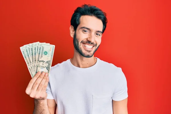 Ung Latinamerikansk Man Håller Dollar Sedel Ser Positiv Och Glad — Stockfoto