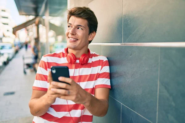 Joven Hombre Caucásico Sonriendo Feliz Usando Teléfono Inteligente Auriculares Ciudad —  Fotos de Stock